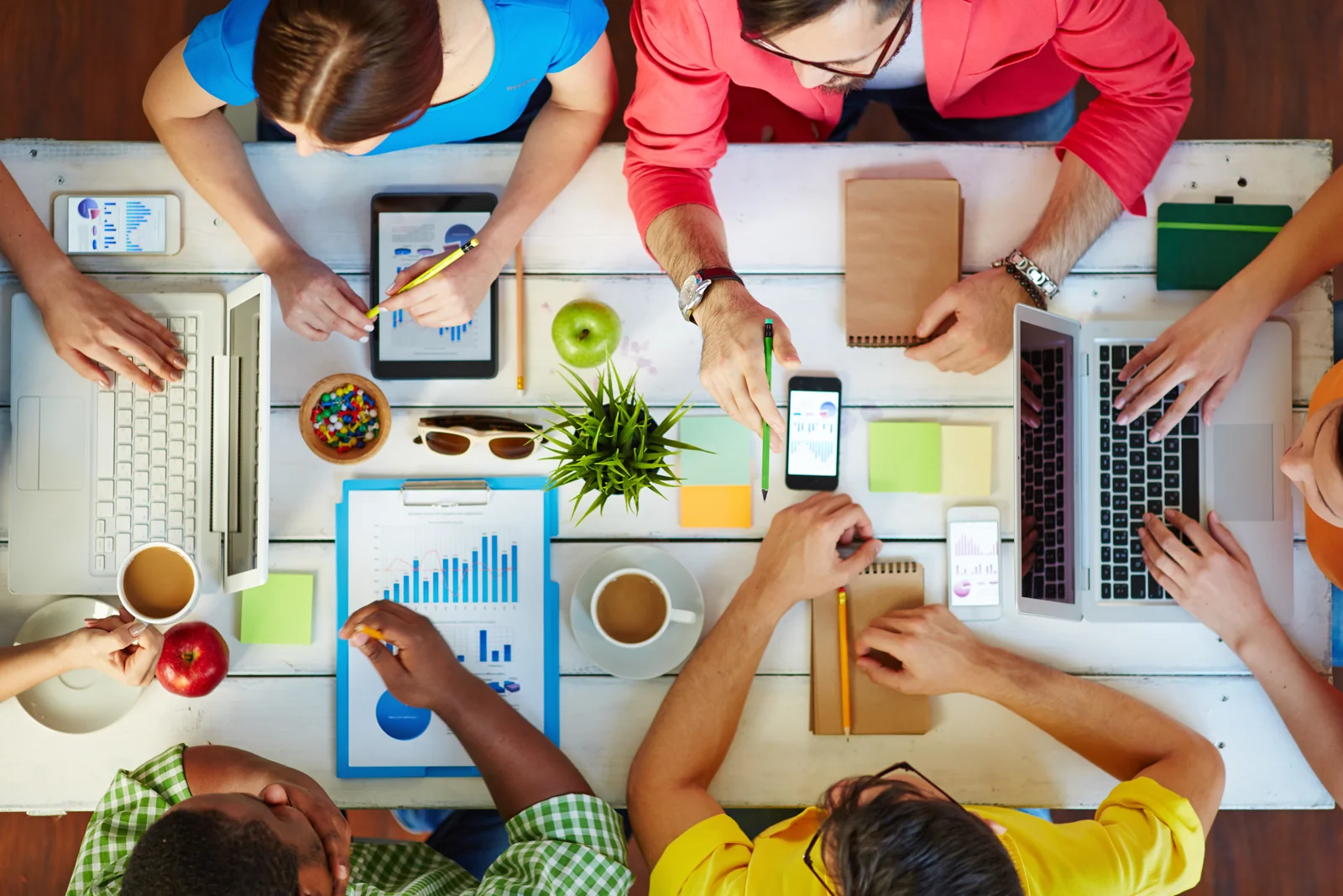 Vista cenital de un equipo trabajando con computadores y gráficos